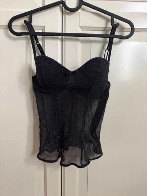 Fest topp - Säljer en svart glittrig korsettopp från intimissmi, helt oanvänd med prislapp kvar 