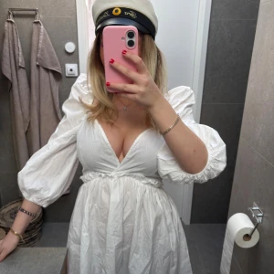 Vit omlottklänning med puffärm - Säljer en vit klänning med djup v-ringning och puffiga trekvartsärmar. Klänningen har markerad midja och ett flowy fall, perfekt för student eller sommar. Finns en liten fläck på baksida axel, inget man tänker på så mycket, går säkert bort i tvätten men utöver de jättefint skick!🤍🤍🥂🥂