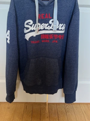 Superdry hoodie - Helt ny Superdry hoodie. Skick 10/10 inga defekter. Storlek L passar någon runt 180-185.