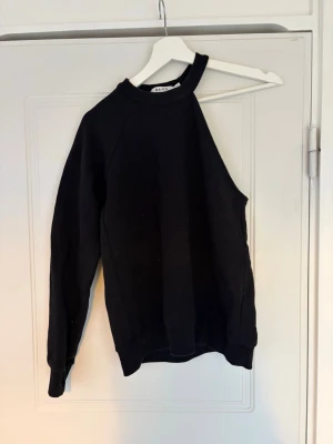 Svart sweatshirt från NA-KD - En svart sweatshirt från NA-KD i storlek S. Tröjan har en klassisk rund halsringning, långa ärmar och ribbade muddar vid ärmslut och nederkant. Tillverkad i mjukt material som känns skönt mot huden. Enkel och stilren design som passar till det mesta.