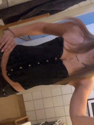 Svart paljettkorsett - Snygg svart korsett täckt med paljetter och hakknäppning framtill. Modellen är axelbandslös och har en figurnära passform som framhäver midjan. Perfekt för dig som vill ha en trendig och glittrig look. Om intresserad kan du fråga om fler bilder privat🥰