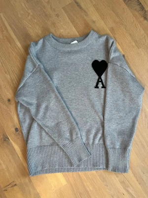 Grå stickad tröja från Ami Paris - Grå stickad tröja från Ami Paris i väldigt bra skick. Hör av dig vid funderingar! 