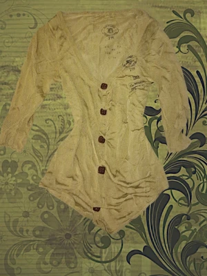 Grön ribbad omlottopp med knappar - Trendig vintage diesel grön omlottopp med ribbad struktur och stora knappar framtill. Toppen har trekvartsärm och en smickrande v-ringning. Perfekt för dig som gillar en avslappnad men ändå stilsäker look.