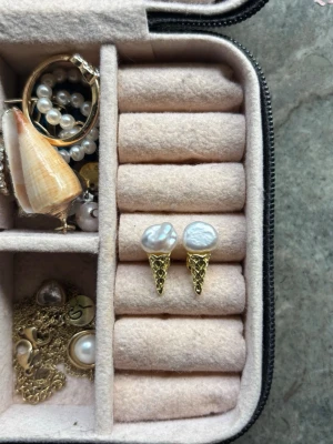 Glassformade örhängen med pärlor - Det är handgjorda i en liten butik i Paris, aldrig använda och köpta för 600kr! 💕Unika örhängen i form av glassar med guldfärgade strutar och oregelbundna vita pärlor som glasskula. Perfekt för dig som vill ha något lekfullt och trendigt i smyckeskrinet. Säljs som ett par. 