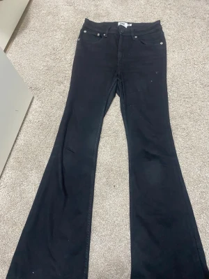 Svarta utsvängda jeans från lager 158 - Säljer ett par svarta jeans från lager 157  med utsvängda ben och klassisk femficksmodell. Jeansen har hög midja och är tillverkade i ett stretchigt bomullsmaterial. Perfekta för dig som gillar retrostil och vill ha ett statement-plagg i garderoben.