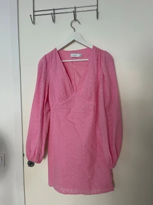 Rosa broderad klänning från Vila - Supersöt rosa klänning från Vila med broderade blommor, v-ringning och långa puffärmar🩷 Liknar Adoore klänningar och är verkligen jättefin till exempelvis midsommar!🌸Endast använd 1 gång🥰