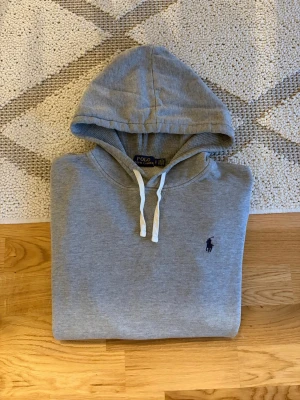 Grå Hoodie Från Polo Ralph Lauren - Hej! 👋 Säljer en riktigt snygg Polo Ralph Lauren hoodie i storlek S. Grå (en klassisk och lättmatchad nyans!) ✨ Mycket fint begagnat skick! En riktig kvalitetshoodie. 🎉 Grymt skön och sitter riktigt bra (Storlek S) 👕 Den klassiska broderade pony-loggan på bröstet!  Alla tvättlappar sitter kvar (se bilder). ✅ Fraktar snabbt! 🚚📦 Hör av er vid frågor! 💬💯 