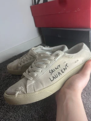 Saint Laurent skor - Beige/vita skor från Saint Laurent, storlek 40 men sitter som 41, innermått 26 cm. Skicket är bra och de saknar defekter på utsidan, det är endast innersulan som är lite sliten. Dustbag medföljer. Hör av er vid frågor!