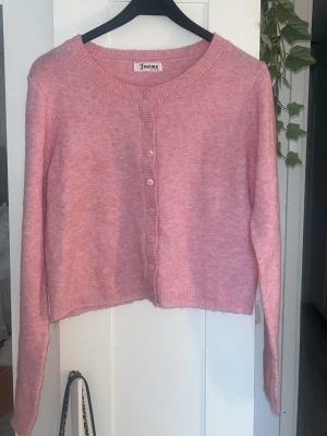 Rosa cropped kofta från Jwinme - Söt rosa cropped kofta från missäy med rund halsringning och knappar framtill. Koftan har långa ärmar och är stickad i ett mjukt material. Den är i one size men sitter ungefär som en Xs-S. Koftan har tyvärr inte kommit till användning hos mig💘