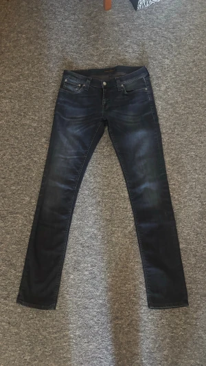 Mörkblå nudie jeans - Jeansen är modellen tight long john. (Kolla nudies egna modell guide om du undrar nåt) Jeansen sitter slim/skinny och är i mycket bra skick. Priset är diskuterbart