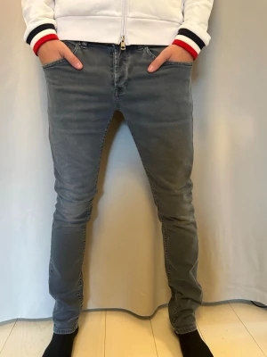 Dondup George Jeans - Trendiga Dondup jeans i grått som ger en modern och stilren look. Jeansen har en snygg passform och passar både till vardag och mer uppklädda outfits. I mycket gott skick utan anmärkningar. Storlek: 32. George Hör gärna av dig vid frågor!