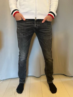 Dondup George Jeans - Stilrena trendiga svarta jeans från Dondup, den mörka tvätten och snygga slitningarna ger ett rent och mångsidigt uttryck som passar både till vardag och mer uppklädda tillfällen.  Jeansen har en smickrande passform och hög komfort. I mycket gott skick! Skriv vid funderingar!