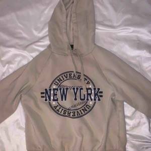  - Hoodie från Gina Tricot Beige med svart tryck i mitten I använt skick