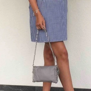  - Stella McCartney liknande väska från Tiamo i den minsta modellen,grå med silver kedja.  Köparen stör för frakten 