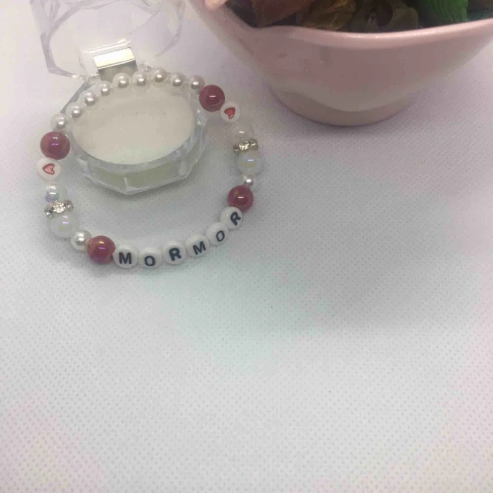 Armband ” MORMOR” kärlek    Fin armband i vit och röda pärlor.  Handgjorda med elastiktråd och passar till alla handleder. Storlek : 17-18 cm. Accessoarer.