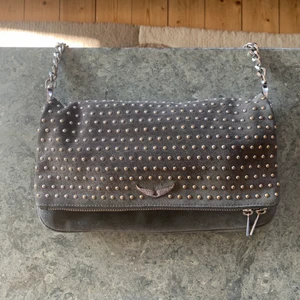 Zadig väska - Säljer min fina Zadig väska då jag inte längre använder den. Den är i grå mocka med silvriga detaljer. Kort och lång kedja finns. Kvitto, dustbag och påse till väskan finns kvar! Köpt på Zadig butiken i Paris! Skriv för fler bilde! Högsta bud 900