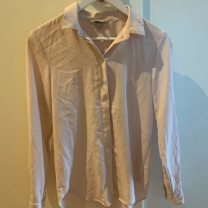 Skjorta från hm - Rosa skjorta från hm! Den knäpps med en gullig knapp längst upp. Det är en tygbitar över alla knapparna så att de ej syns. Använd Max 3 gånger! Storlek 32! Frakt tillkommer! 