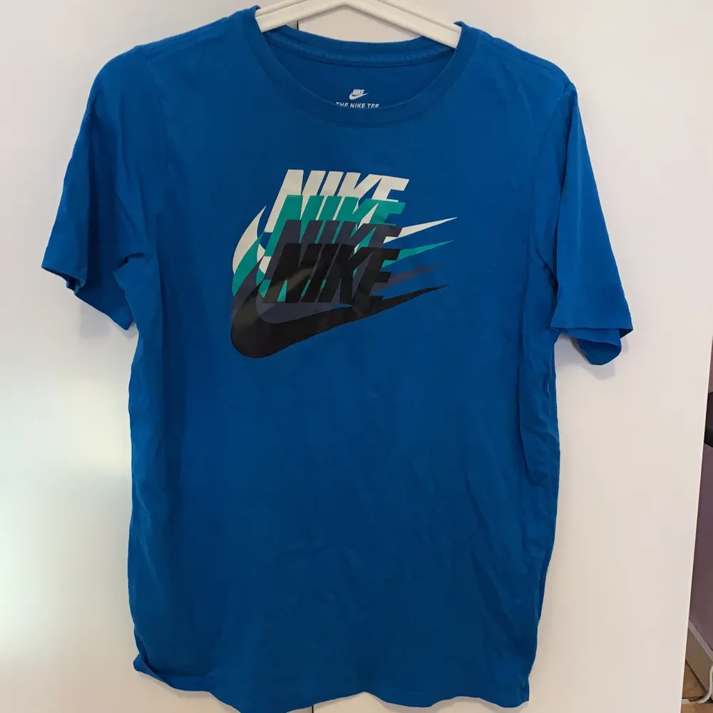 En Nike t-shirt i storlek 158-170 (se bild 2). Den är lite ljusare blå än vad den är på bilden. Den är i nyskcik och är köpt för ca 250kr. Frakt ingår, skriv för intresse!. T-shirts.