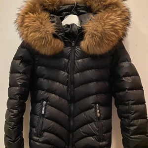 Chelsea jacka strl 36 - Varm vinterjacka i storlek 36, köpt på chelsea i gbg. Köpt för 2000kr och säljs för 500kr. Använd två vintrar och fint skick förutom en knapp som lossnat vid pälsen men som lätt går att fixa med ett gem som man inte kommer se. Det är också äkta päls runt luvan. 