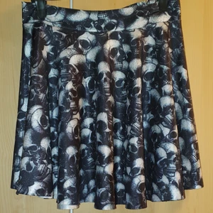 Kjol med dödskallar Ca. Strl. S/M - Kjol med dödskallar Ca. Strl. S/M. Kjolen är väldigt stretchig och har resår bak i midjan så passar även på mig som har Ca. L-XL. Dock blir kjolen kortare då. Köpt på second hand men bara använd en gång av mig. Mycket bra skick. Priset kan diskuteras. Skickas mot fraktkostnad.