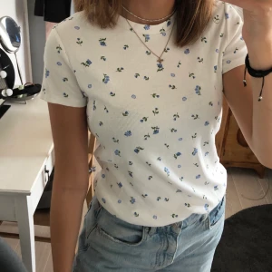 Blommig topp -  T- shirt från monki med söta blå blommor på som aldrig är använd :( Den är ribbad, stretchig och otrooooligt skön och förtjänar därför att komma till användning! Kontakta mig för ytterligare bilder eller frågor