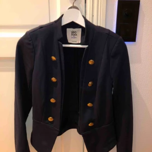  - Mörkblå kavaj med guldiga knappar