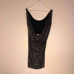  - Svart klänning med silverglittrigt ”stänk” prickar. Djup i ryggen! Nyskick! 