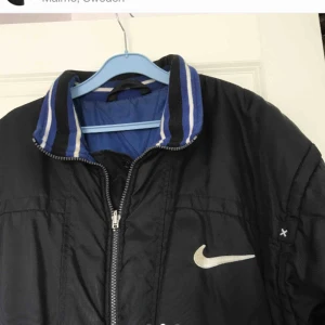  - Varm jacka Nike storlek M. Använd men i mycket bra skick! Kan vändas ut och in till blå eller svart färg.