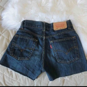  - Superfina blå Levi’s jeansshorts i nyskick, med lite fransar längst ner! Perfekta till sommaren! Waist : 24 Length : 26 . Säljer pga för liten storlek.