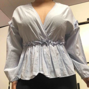  - Ett fint himmelsblå plagg från zara, med volanger vid armarna nästan axeln och runt midjan. V ringning vid brösten, man kan lägga en nål ifall man vill täcka brösten, den är använd några gånger. Säljer pågrund av att de inte är min still längre 