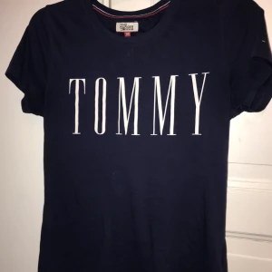 Tommy Hilfiger  - Marinblå Tommy Hilfiger tröja med tryck och märke på vänster arm, Använd ca 5ggr.                                                                  Nypris:250-300kr   