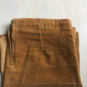 Fejkmocka kjol från Brandy Melville  - Kort rak kjol från Brandy Melville. Fejkmocka textil och dragkedja därbak. 