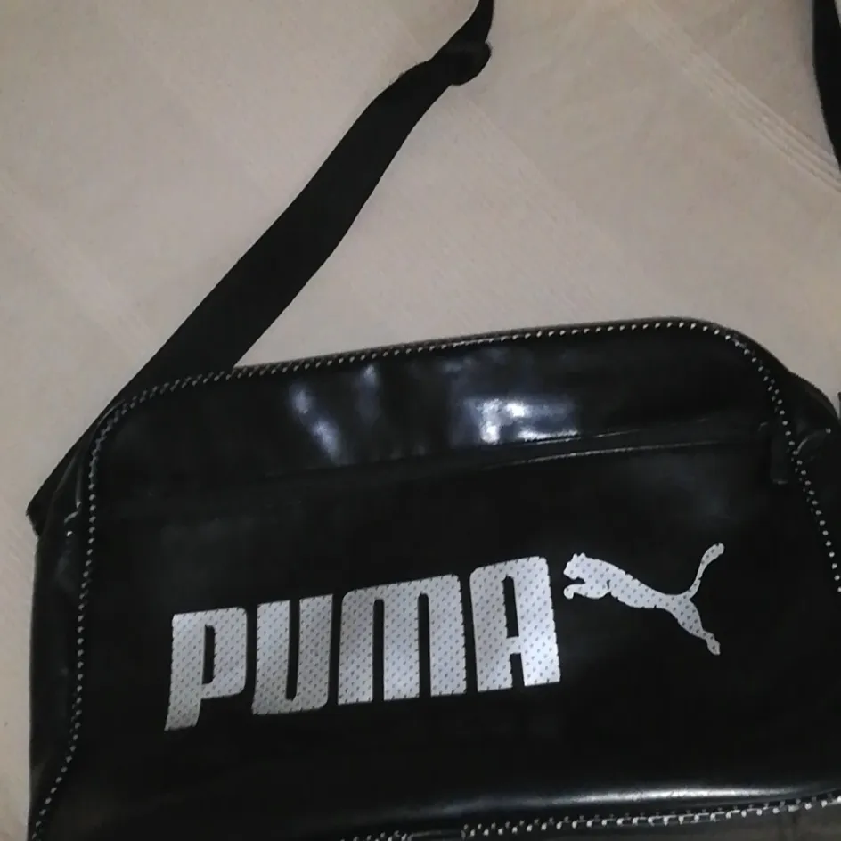 Säljer denna snygga puma väskan pga att den inte kommer till andvändning längre. Den är dock lite sliten i kanterna som man ser på bild 3. Men annars är den i bra skick. Köparen står för frakten på ca 60kr  Den är 39×27 cm. Betalningen sker genom swish.  . Väskor.