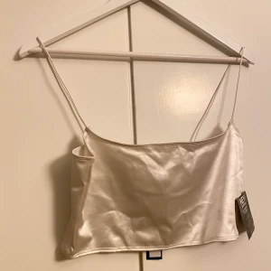 NLY ONE - Säljer denna otroligt fina Stretch satin grop top från Nelly i storlek M. Toppen var tyvärr för liten för mig och där av anledningen att jag säljer. Original pris på tröjan är 199kr och jag säljer den för 150kr vid snabb affär. Kan hämtas i Bollnäs annars betalar du frakt, jag kan även åka till Gävle och mötas upp utan frakt kostnad ✨