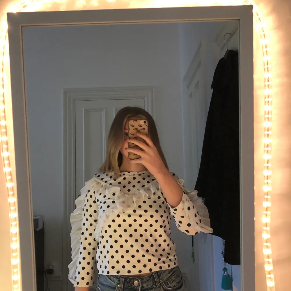 Monki croptop str S med 3/4 ärmar. Prickig och vit volang detalj på framsidan. Blusar.