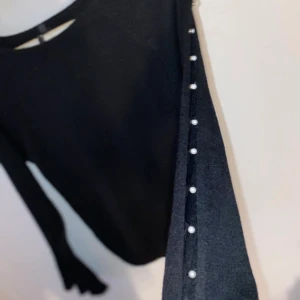 Tröja - En svart tröja med vida armar och jättefina pärlor på sidan av armarna! ( frakt tillkommer )