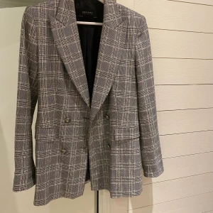 Rutig kavaj - Supersnygg rutig kavaj från zara i storlek s. Kavajen går att dubbelknäppa fram till men också snyggt att ha den uppknäppt.   Blivit lite smink högst upp på kragen men inget som syns när man har den på sig, därav det billiga priset. Annars är kavajen i jätte bra skick. Skickar gärna om köparen står för frakt. 
