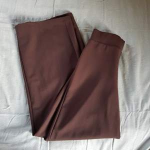Bruna långa  utsvängda byxor från ginatricot, väldigt fint skick bara använt en gång, de är högmidjade och långa i benen 