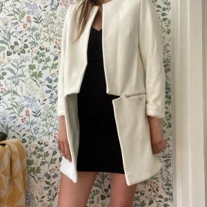 Samsoe samsoe kappa - En gräddvit kappa med snyggt snitt. Tyvärr en fläck, se bild 2. Kan säkert gå bort med vanisch eller om man lämnar in jackan. Sparsamt använd. 