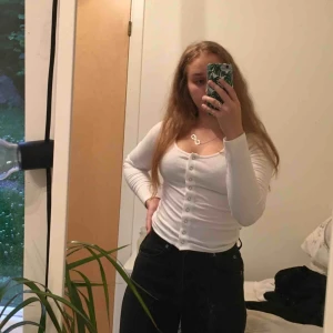  - Vitt tajt tröja med knappar på framsidan som går att knäppa upp, kan ha den både knäppet och öppen. I mycket bra skick 