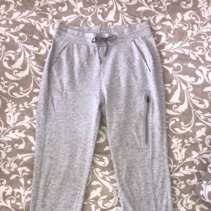 Byxor S - Ljusgråa mjukingbyxor i tunt tyg med en ficka på ena sidan, storlek S, (har även en supereliten blå fläck på framsidan)  du står för frakten!