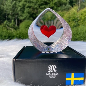 Målerås handmade Crystal Heart - Målerås kristallhantverkshjärta perfekt som en present till en älskad. Mått 70 mm x 75 mm x 35 mm. Hjärtat har 2 små ytskador på baksidan som syns på bilderna. Det finns en originalförpackning. Nytt i butiken kostar 499KR