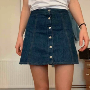  - Jeanskjol med knäppning framtill. Storleken är 34/36. En liten, knappt märkbar fläck (skriv så skickar jag bild), annars i bra skick. Frakt tillkommer 💌