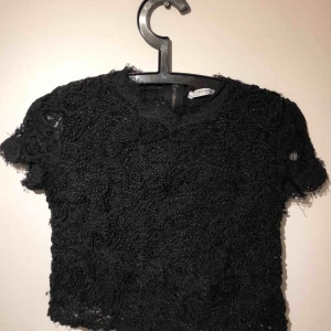 Spetstopp  - En svart mönstrad jättefin topp från Zara. Använd fåtal gånger. Dragkedja på baksidan som går hela vägen ner. Köparen står för frakt!