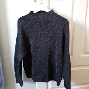 Glittrig tröja - En glittrig tröja i tjockare material och högre hals