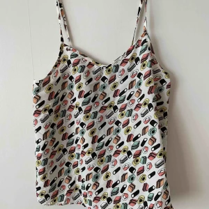  - Ett linne med godisar på. Storlek S men passar lika bra på en M / L.  Helt oanvänt.  +frakt 