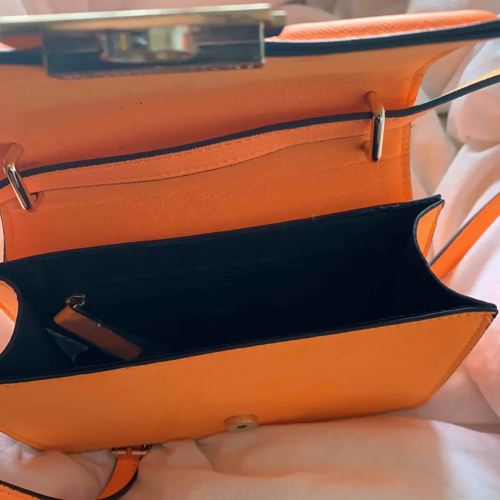 Snygg lysande orange väska. Endast använd en kväll! Längre band. Kan skicka fler bilder vid intresse☺️. Väskor.