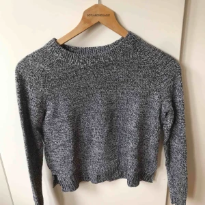 Stickad tröja - Stickad vit- och svartmelerad tröja från h&m i något boxig modell. Möts upp i Stockholm, vid frakt står köparen för denna.