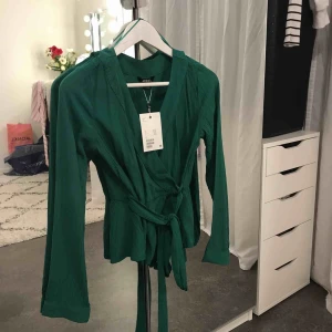  - Grön draperad blus från Monki. Aldrig använd. Nypris 250 SEK.