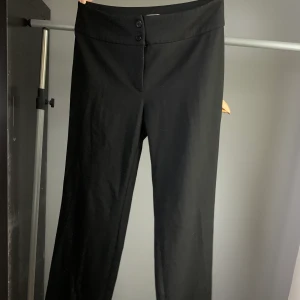 Svarta högmidjade kostymbyxor - Högmidjade svarta kostymbyxor, endast använda 2 gånger. Säljes pga att de är för långa. Perfekta kostymbyxor för tjejer som är över 170 cm.